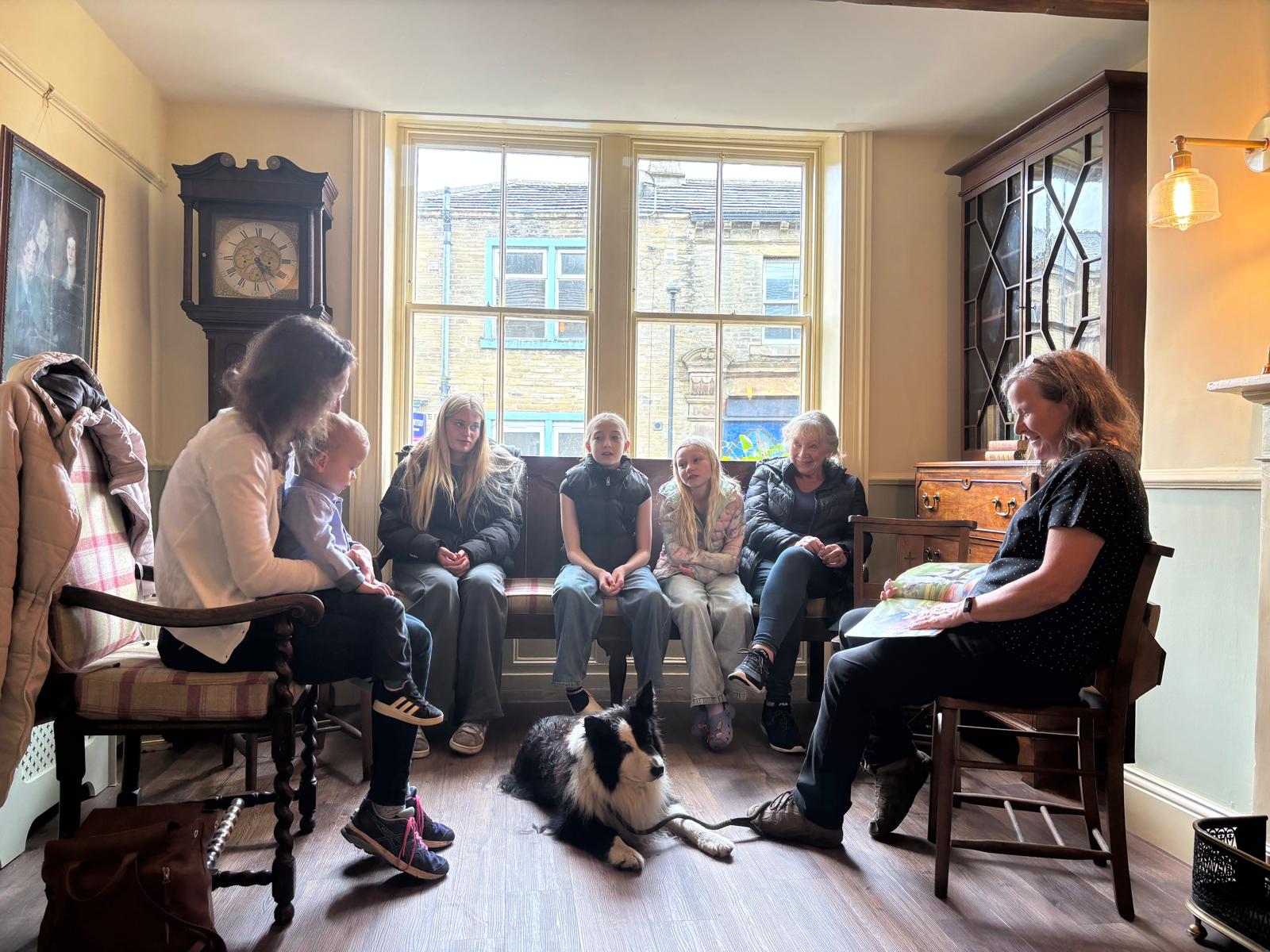 A group of people sat together with a dog laid on the floor