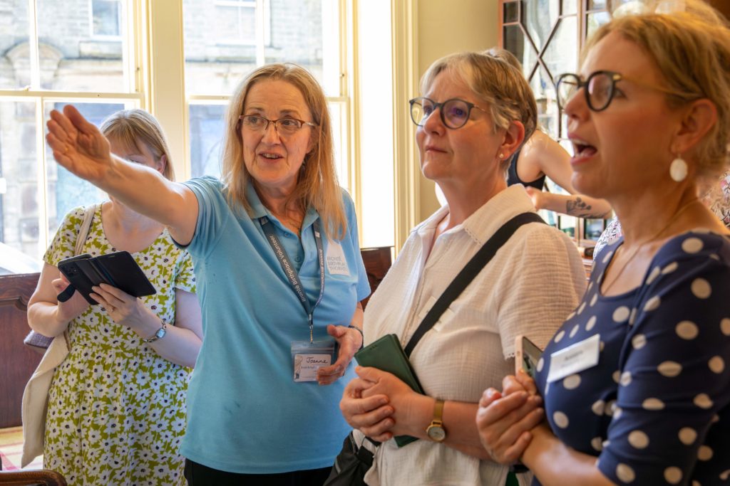 Woman guiding a tour, pointing at something.