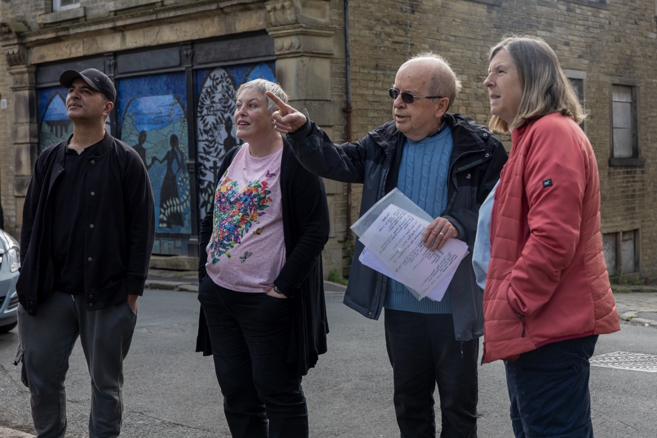 a group of people huddled together in front of an old stone building