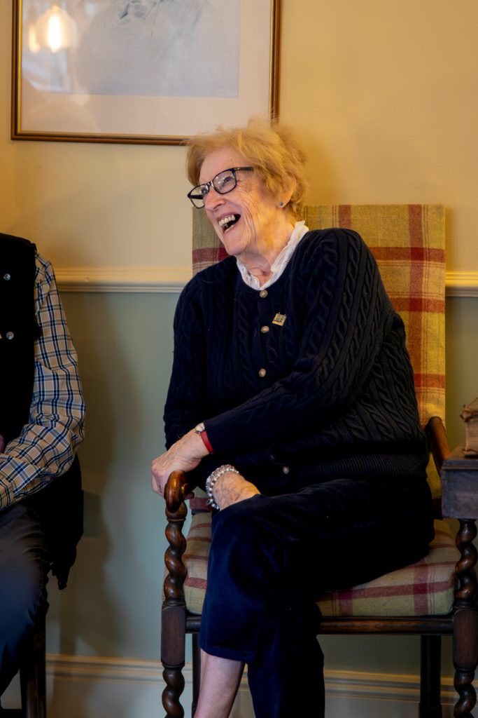 A woman sat on a chair laughing